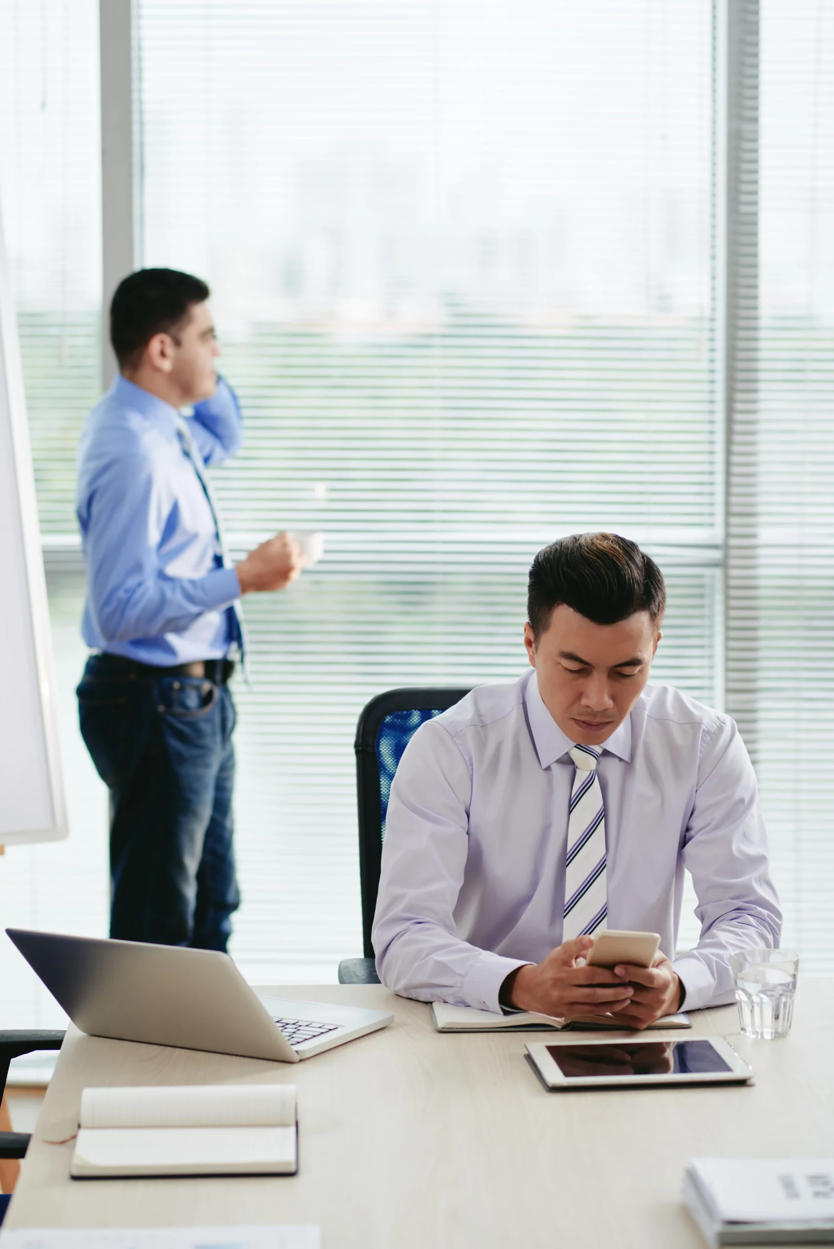asian-man-reading-text-messages-with-his-colleague-making-phone-call-background